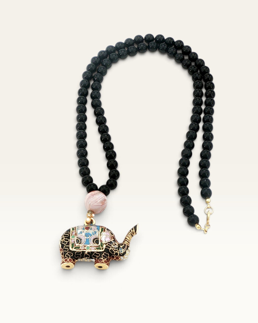 Full-length lay-flat view of black stone bead necklace with cloisonne elephant pendant, banded agate bead, and gold clasp