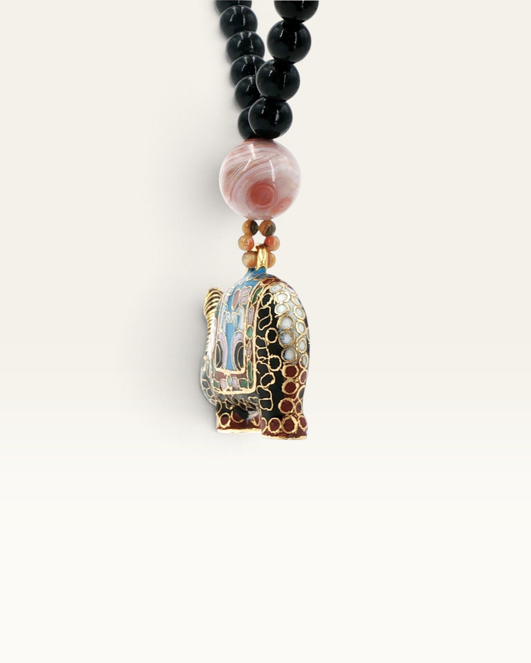 Black stone bead necklace showing rear three-quarter angle of cloisonne elephant pendant with banded agate accent bead