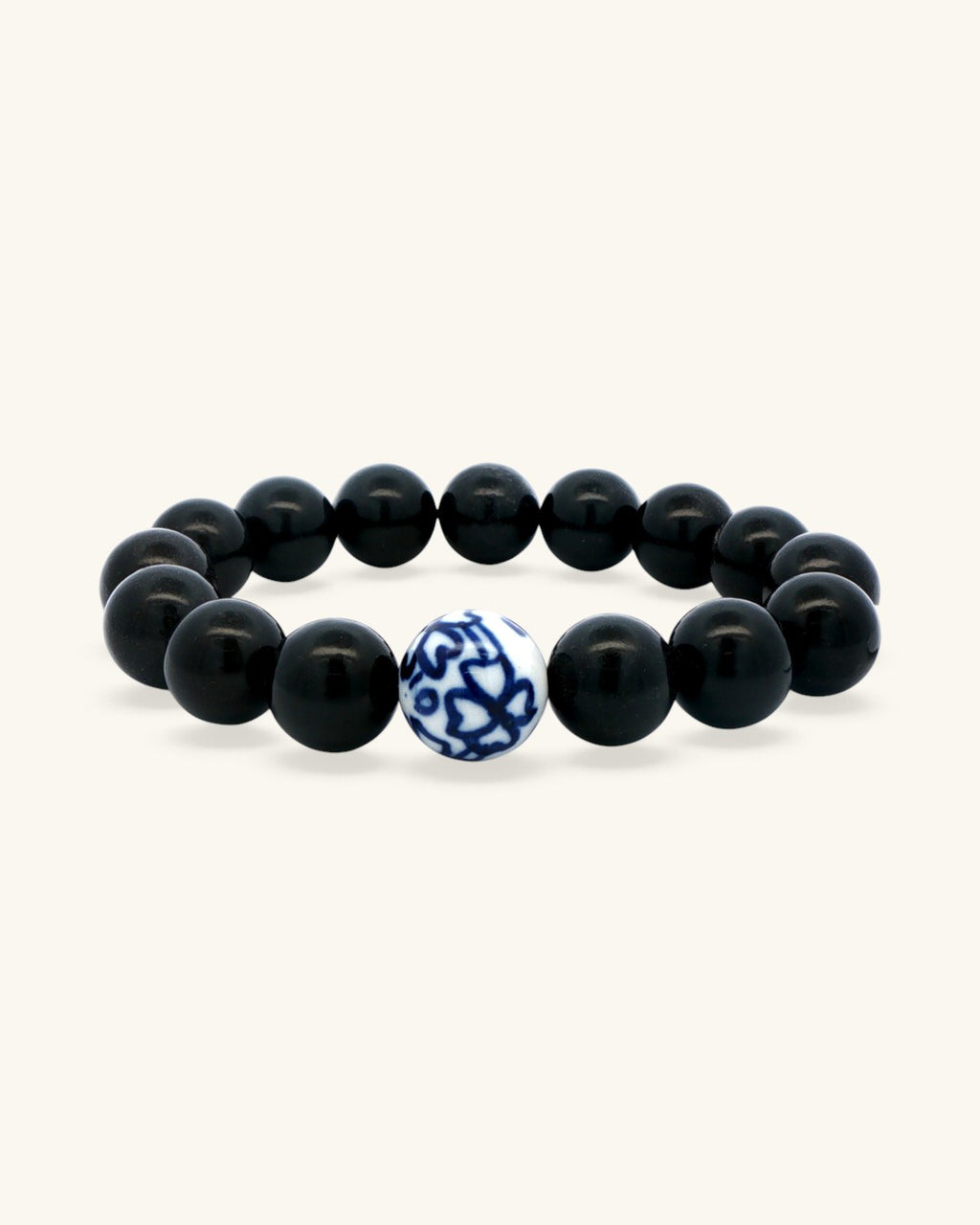 Black obsidian bead bracelet standing upright, front view with the blue and white porcelain bead centered