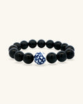 Black obsidian bead bracelet standing upright, front view with the blue and white porcelain bead centered
