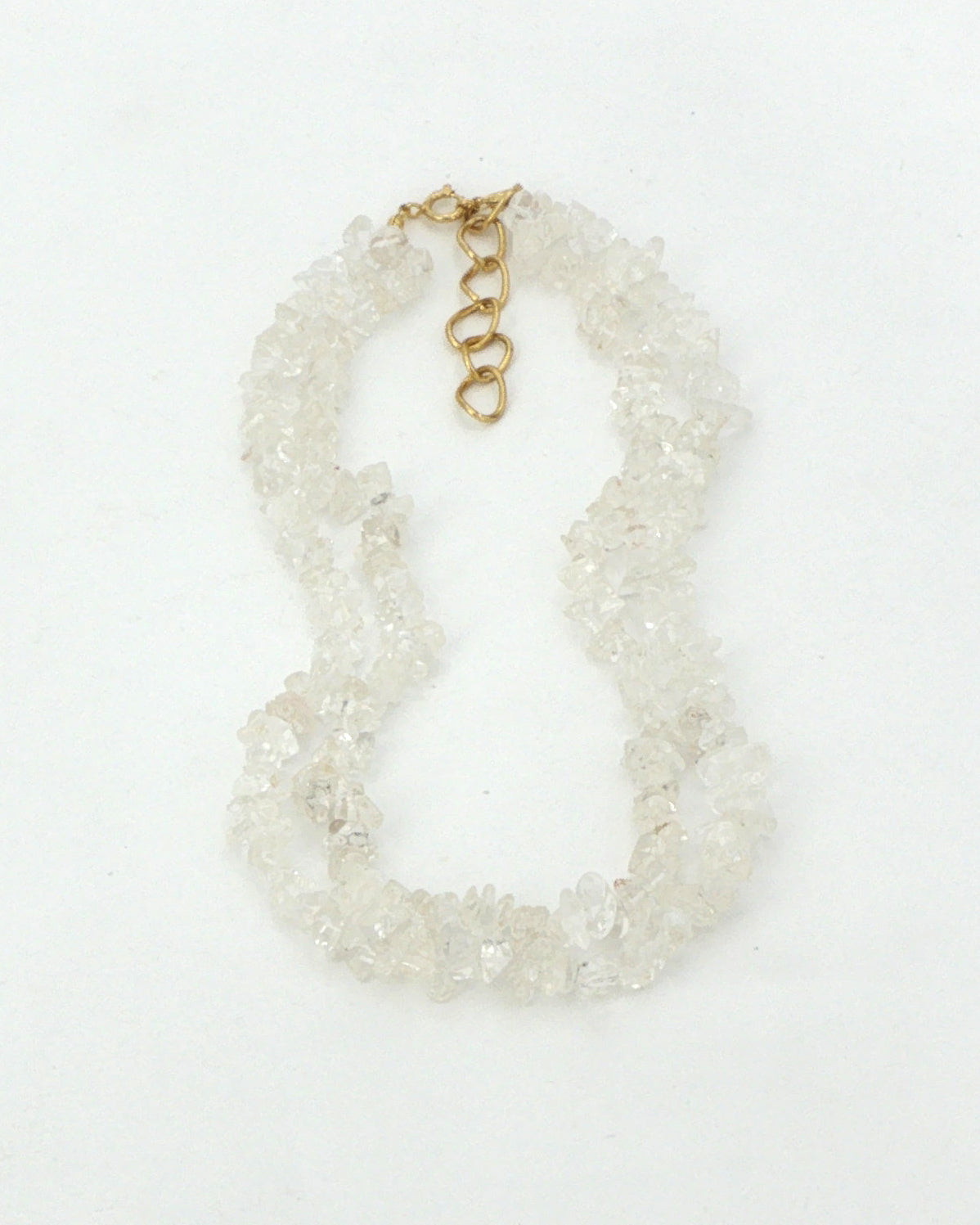 Clear quartz chip necklace, two strands laid flat on white with the gold tone clasp and extender at the top
