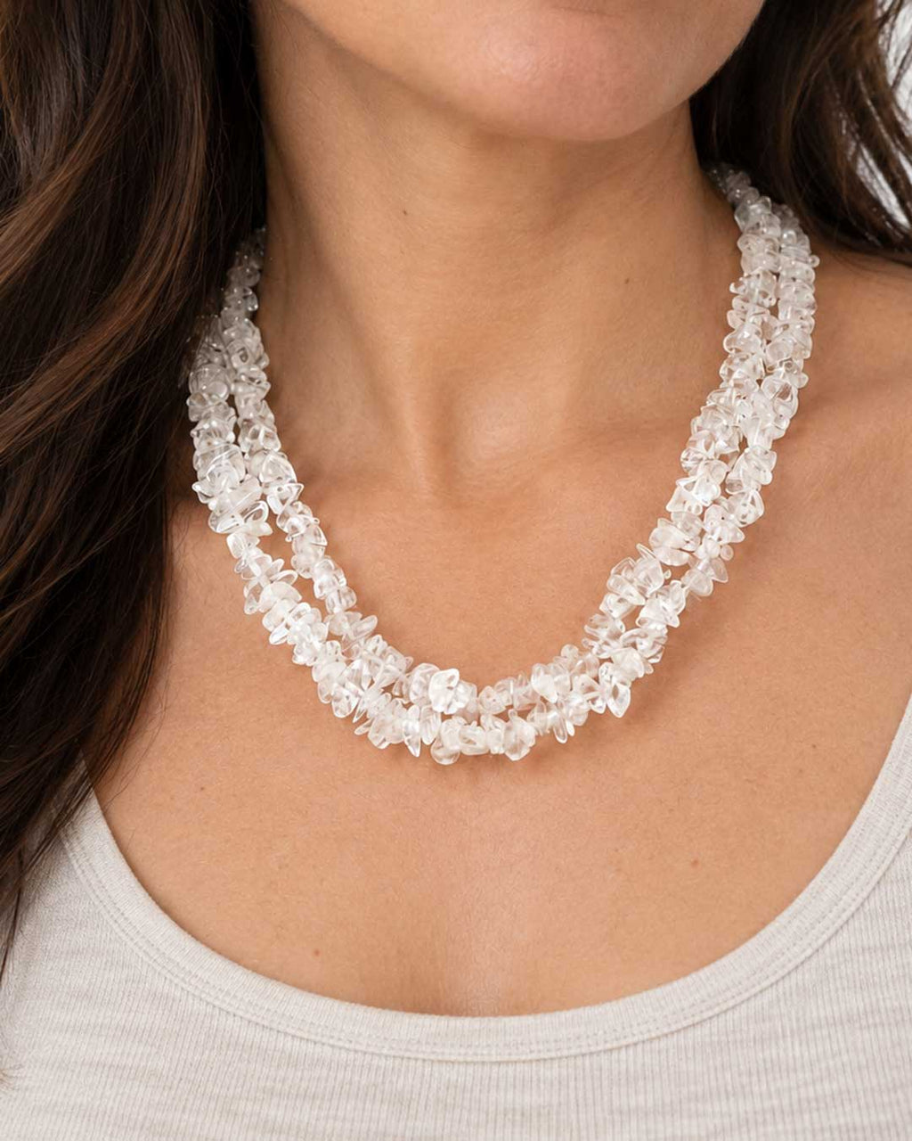 Clear quartz chip double strand necklace worn at the collarbone over a white top, front view on a model