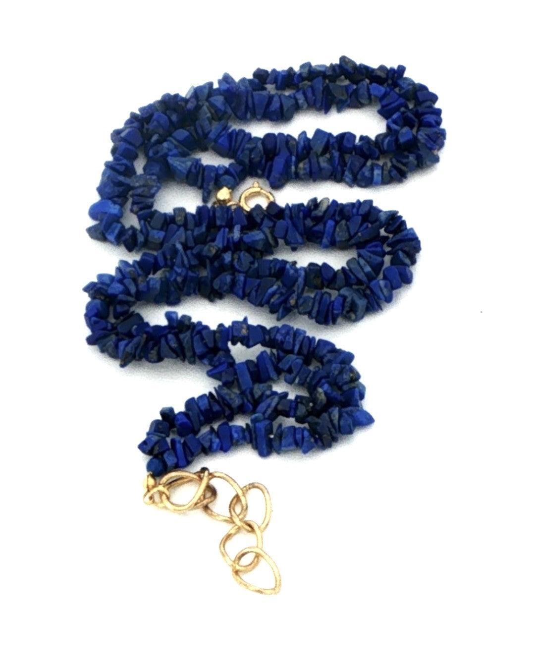 Lapis lazuli chip double strand necklace coiled on white, showing the deep blue chips and gold tone clasp