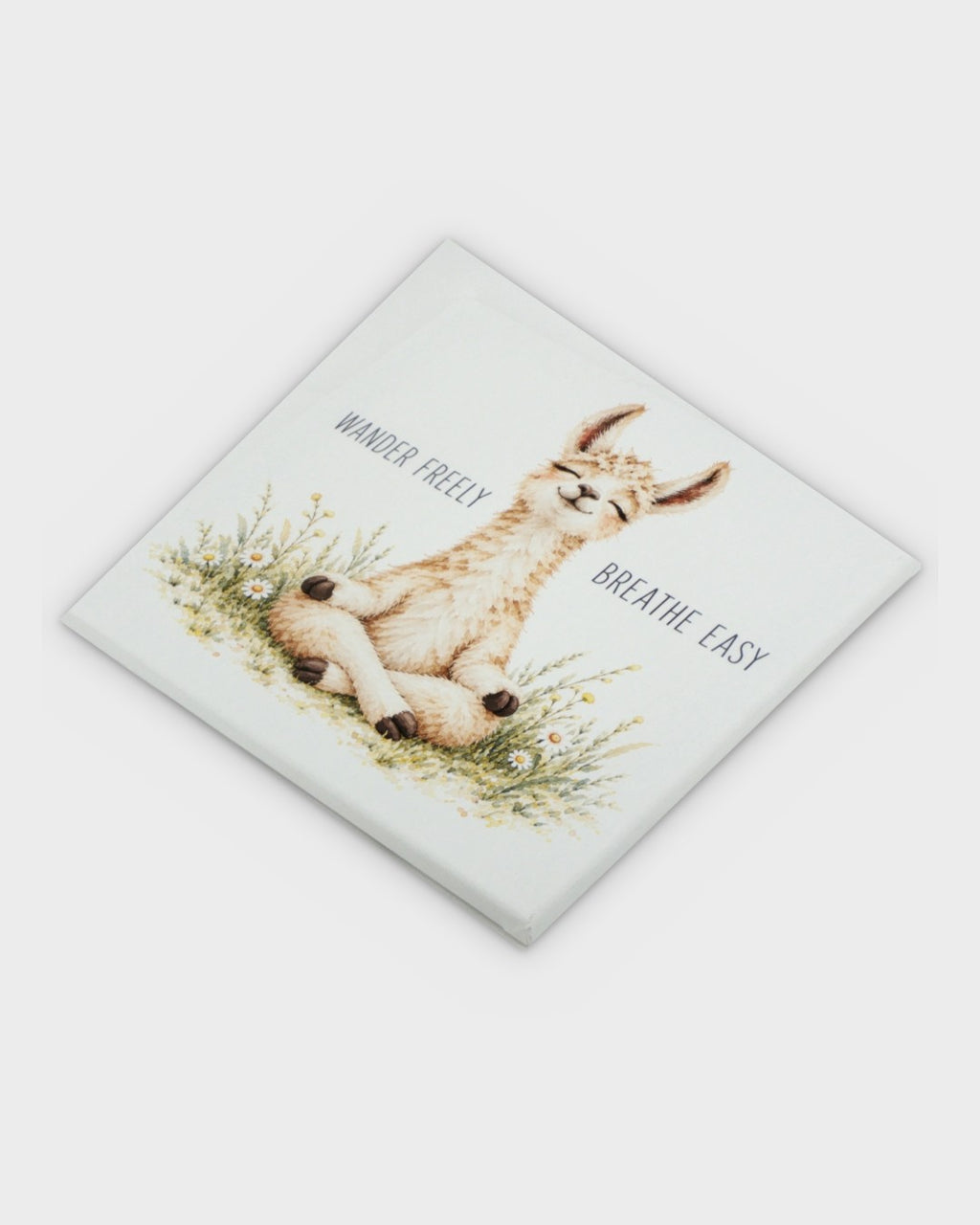 Meditating llama canvas wall art tilted at an angle showing canvas wrap thickness and watercolor llama detail with wildflowers