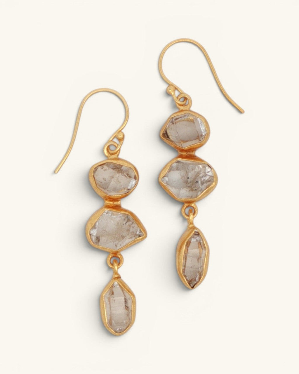 Triple Herkimer quartz gold-plated drop earrings shown as a pair, three stacked raw crystal stones in gold bezels