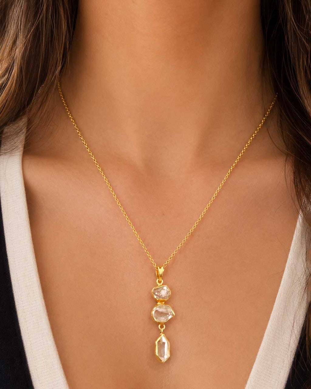 Triple Herkimer Quartz gold-plated pendant worn on a gold chain around a model's neck over a white top, worn view