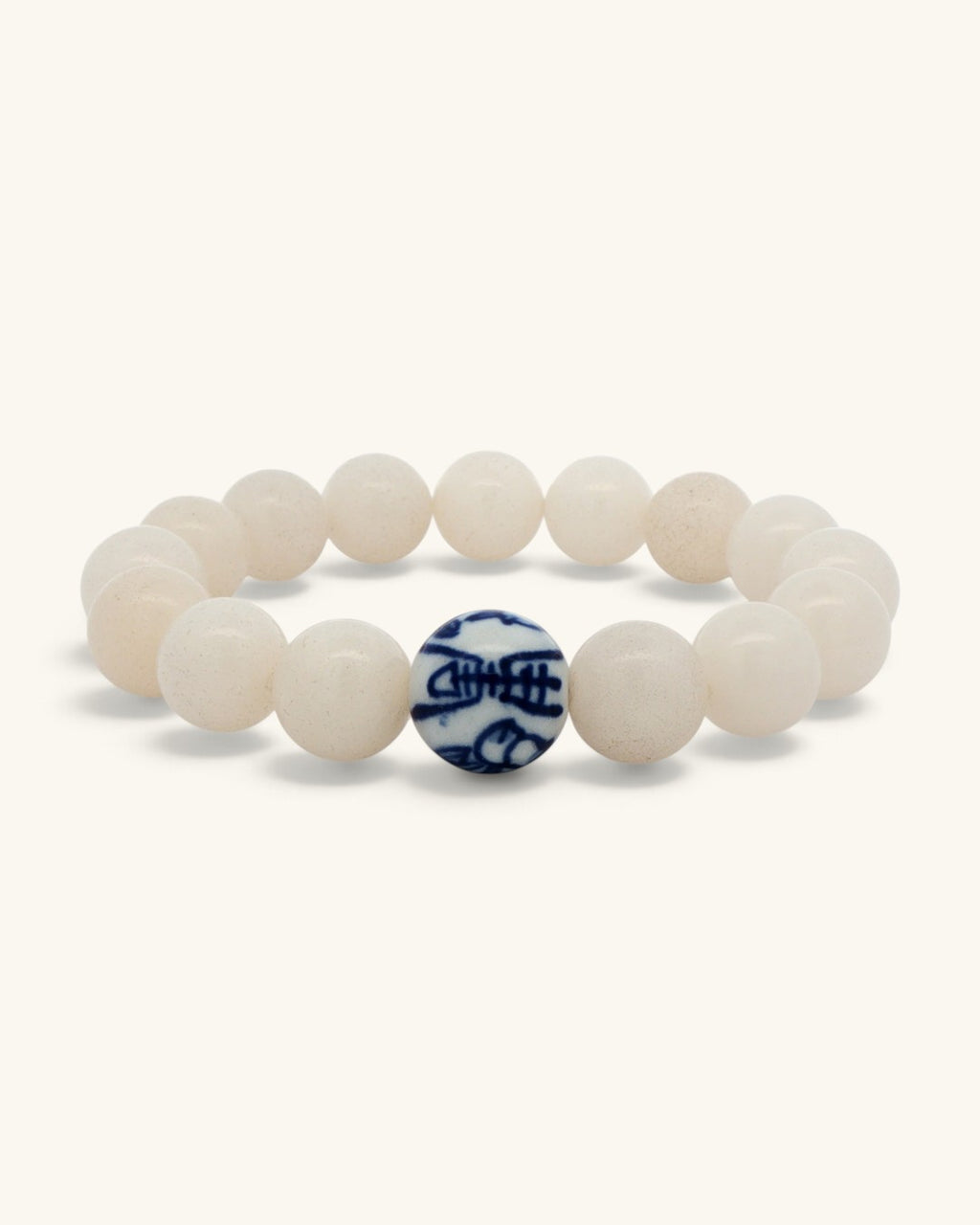 White jade bead bracelet standing upright with the blue and white porcelain bead at the back of the circle